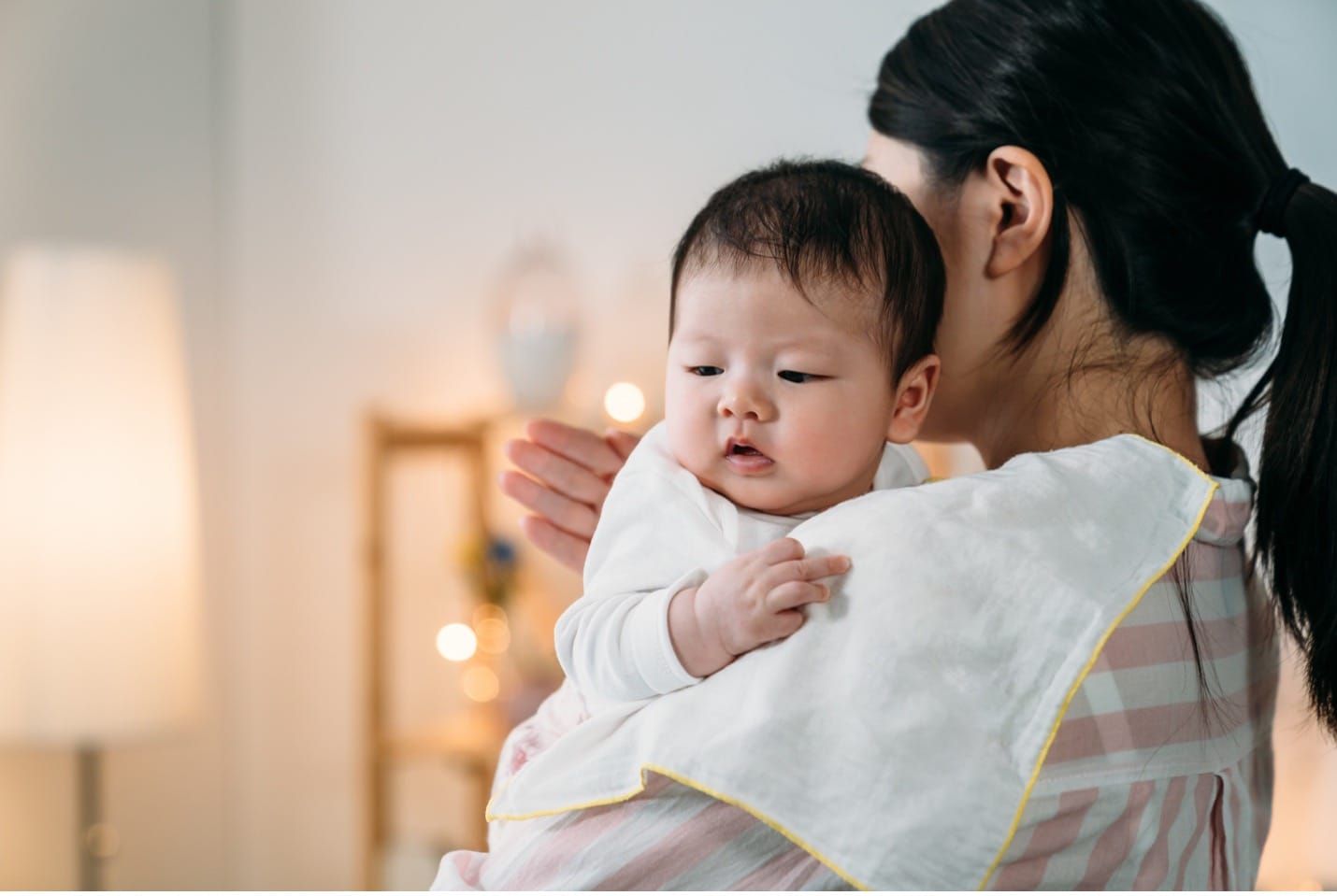 mother burping her baby over her shoulder