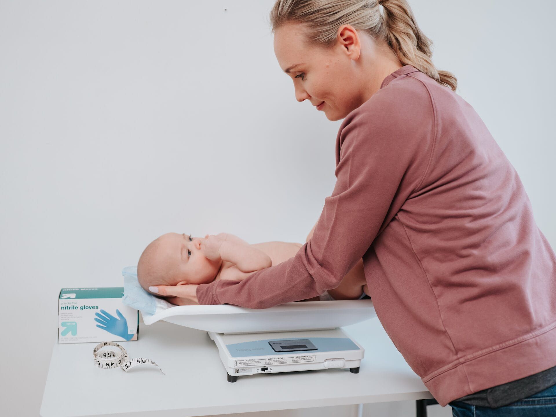 Mom weighing her baby at home.