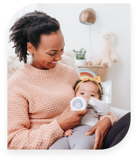 A mother bottle feeds her baby using the nfant® Smart Bottle and best practices taught by the Connected Feeding approach with nfant®.